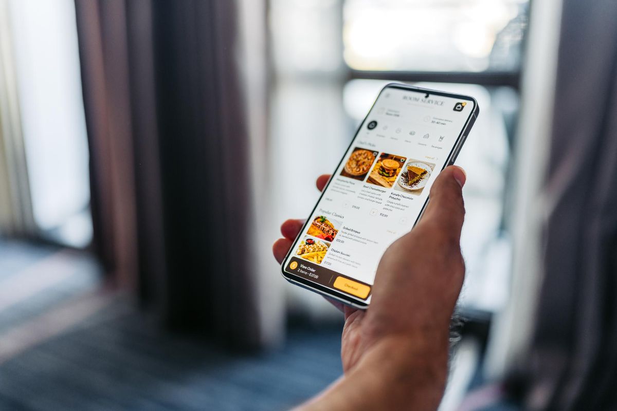 Une carte de restaurant consultée sur un téléphone, plat par plat, avec les prix.